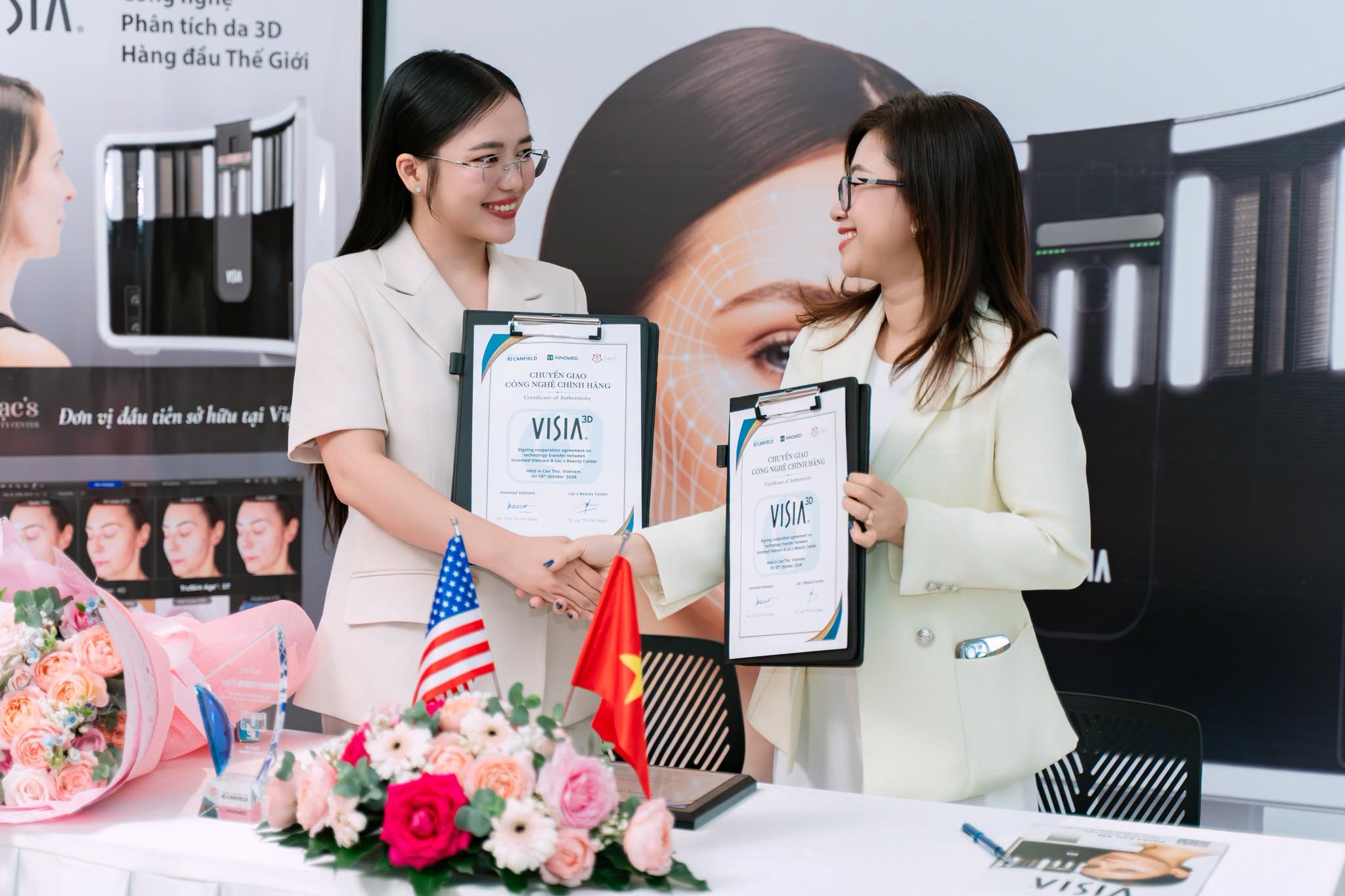 Two people holding VISIA certificates at the Lạc’s Beauty Center handover in Cần Thơ